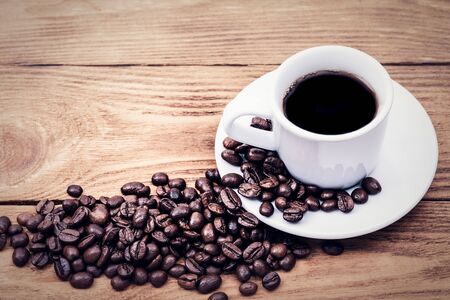 A cup of coffee and scattered coffee beans. Layout. Flat lay. Coffee bean.の写真素材