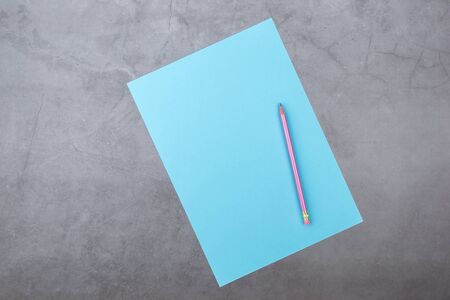 Flat lay, top view, blue sheet and pencil on a gray textured backgroundの写真素材