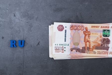 Big stack of Russian money banknotes of five thousand rubles lying on a grey cement backgroundの写真素材