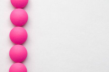 Pink pills in a row on a white background.の写真素材
