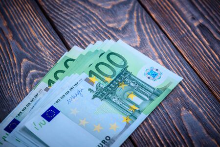Euro cash banknotes on a dark wooden background