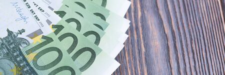 Euro banknotes in fan at wooden background