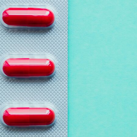 Blister bright red tablets on a green background