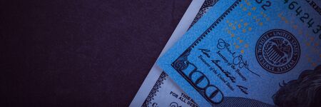 One hundred dollar bills on a gray background