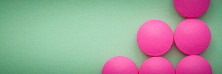 Pink pills laid out on a green backgroundの写真素材