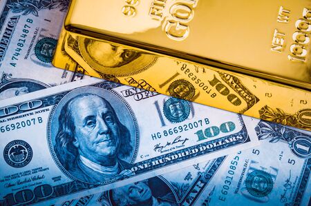 Gold metal ingot on the background of dollar bills