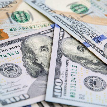 A pile of one hundred US banknotes with president portraits. Cash of hundred dollar bills, dollar...