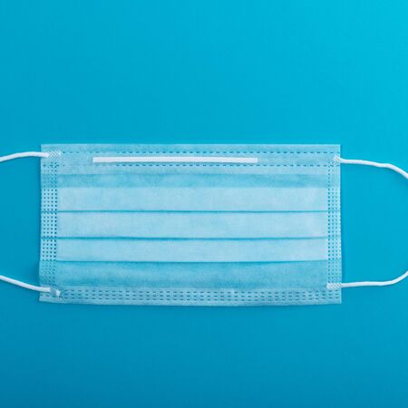 Medical mask surgical protective virus, flu, disease, textile filter. Isolated on a blue background.の写真素材