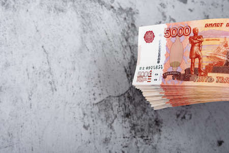 Russian cash banknotes of five thousand rubles, the bundle hangs on a gray background, there is a place for the inscription and text. Layout, mockup.の写真素材