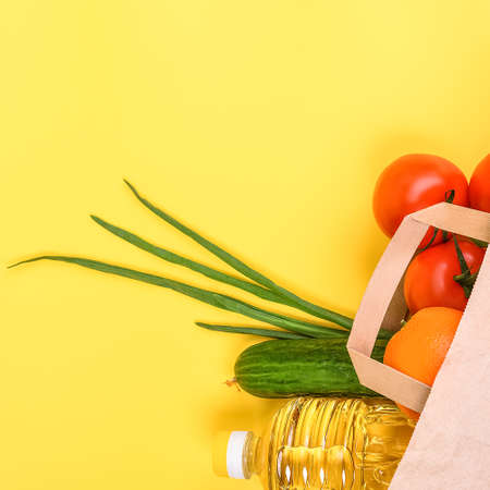 Paper bag with food supplies for the period of quarantine isolation on a yellow background. Copyspace.の写真素材