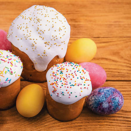 Easter cakes and Easter colored eggs on a wooden background.の写真素材