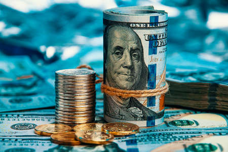 A row of one hundred American dollar bills in close-up against a blue background.の写真素材