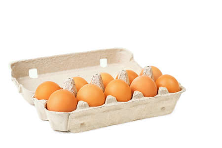 Ten brown eggs in a cardboard box on a white background, isolated.の写真素材