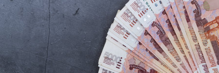 Big stack of Russian money banknotes of five thousand rubles lying fan on a grey cement background.の写真素材