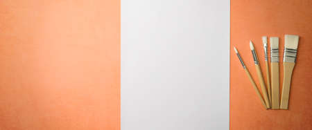 A clean white sheet and brushes on a textured background with space to copy.の写真素材