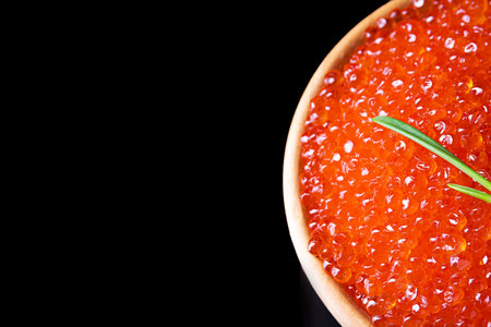 Red caviar in a white cup on a black background.の写真素材