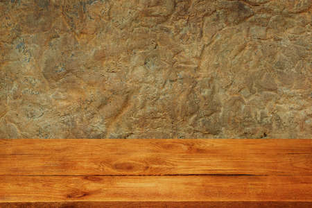 The background is blank wooden boards and a textured plastered wall with lighting and vignetting.