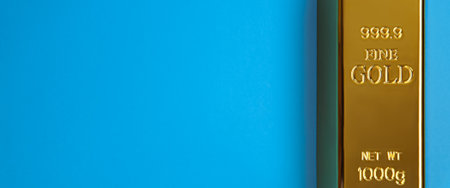 An ingot of gold metal bullion of pure brilliant diagonally located on a blue background.の写真素材