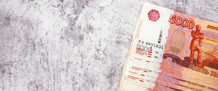 Russian cash banknotes worth five thousand rubles, the bundle lies on a gray background, there is a...