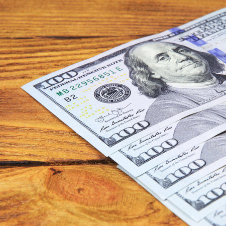 Dollars in a row diagonally on wooden boards.