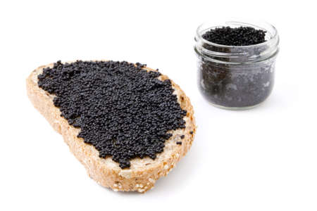 Slice of bread with back caviar. Jar on background. Isolated on whiteの写真素材