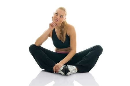 Young women in fitness outfit dreaming. Isolated on whiteの写真素材
