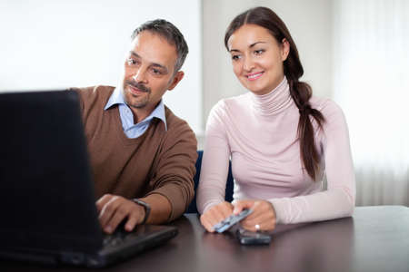 Beautiful woman sitting with a man using laptopの写真素材