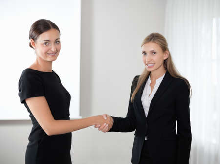 Business women shaking hands making a dealの写真素材