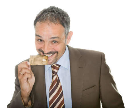 Mature businessman bites his credit cardの写真素材