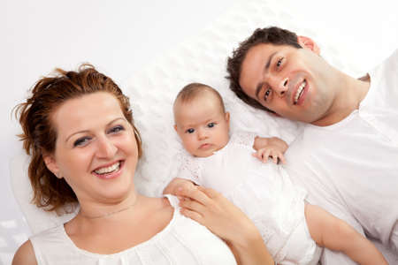 Happy young family lying in bedの写真素材