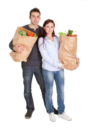 Happy couple with grocery shopping bags. Isolated on whiteの写真素材