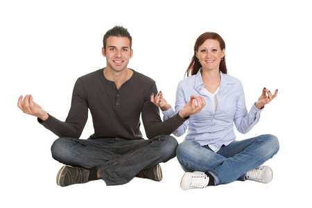 Cheeful young couple doing yoga exercise. Isolated on whiteの写真素材