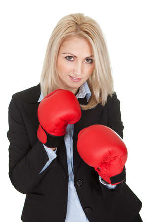 Beautiful businesswomen posing with boxing gloves. Isolated on whiteの写真素材
