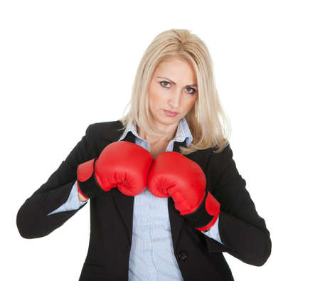 Beautiful businesswomen posing with boxing gloves. Isolated on whiteの写真素材