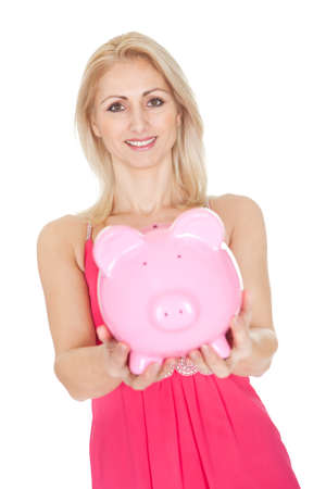 Beautiful woman holding a piggybank. Isolated on whiteの写真素材