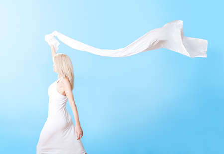 Portrait of beautiful young woman in summer dress on sky backgroundの写真素材