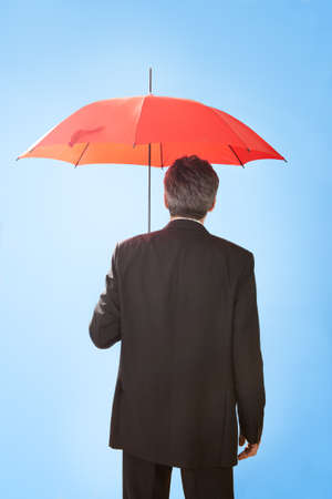Portrait of senior businessmen holding a umbrella.の写真素材