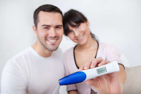 Young couple finding out results of pregnancy test at homeの写真素材