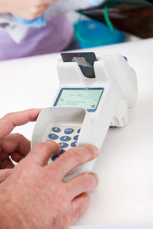 Close-up on customer entering pin code in retail store