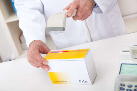 Pharmacist scanning barcode using scanner at drugstoreの写真素材