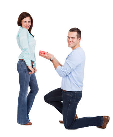 Young man giving present to his girlfriend. Isolated on whiteの写真素材