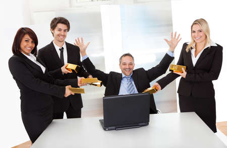 Portrait of happy businessman receiving gold barsの写真素材