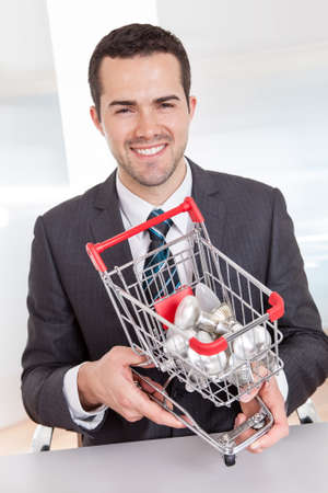 Businessman holding shopping basket full of light bulbsの写真素材