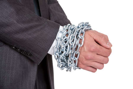 Businessman hands bound in chains. Isolated on whiteの写真素材