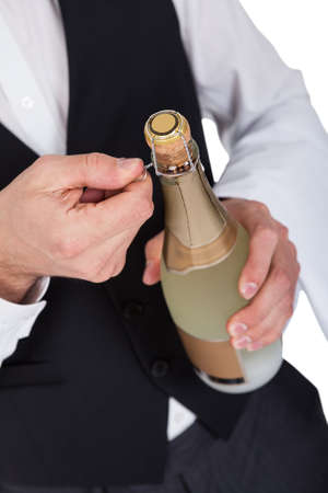 Close-up of butler opening bottle of champagneの写真素材