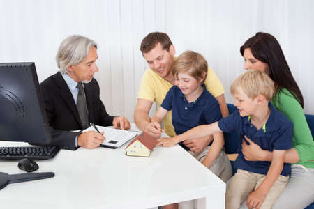 Family in real-estate agency talking construction plannerの写真素材