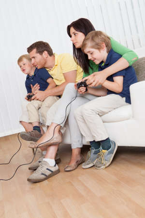 Young family having fun playing videogames at home