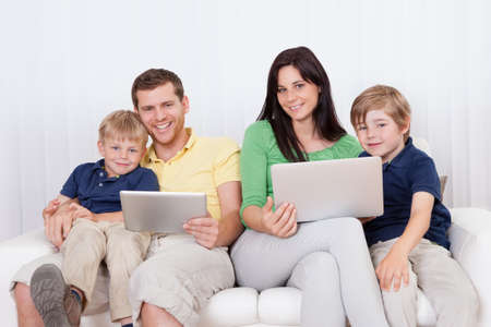 Happy family spending time together and using laptop at home