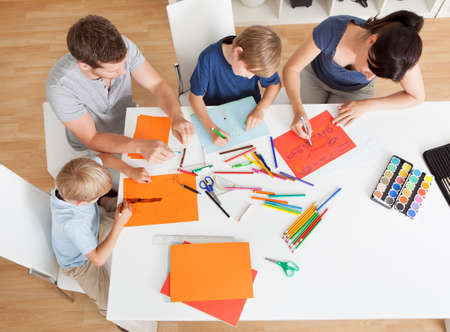 Young family drawing together with colorful pencils at homeの写真素材