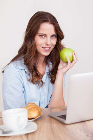 Woman sitting at her desk working on her laptopの写真素材